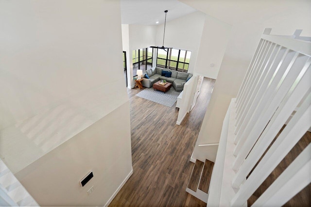 stairs featuring hardwood / wood-style flooring and high vaulted ceiling