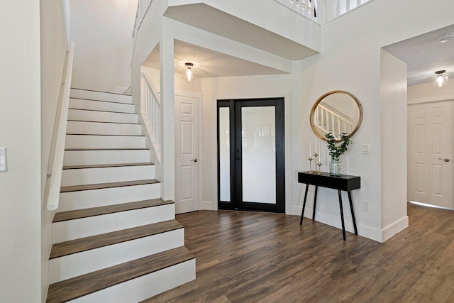 foyer entrance with a textured ceiling and dark hardwood / wood-style floors