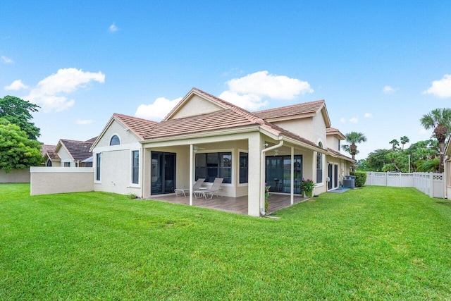 back of property with a lawn, central air condition unit, and a patio area