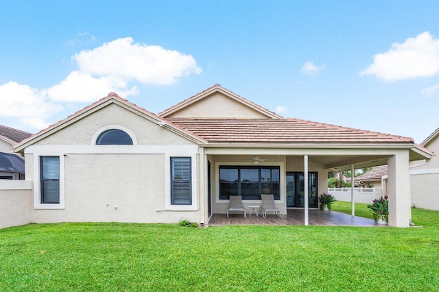 back of property with ceiling fan, a patio area, and a lawn