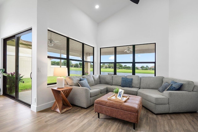 living room featuring hardwood / wood-style floors, high vaulted ceiling, and ceiling fan