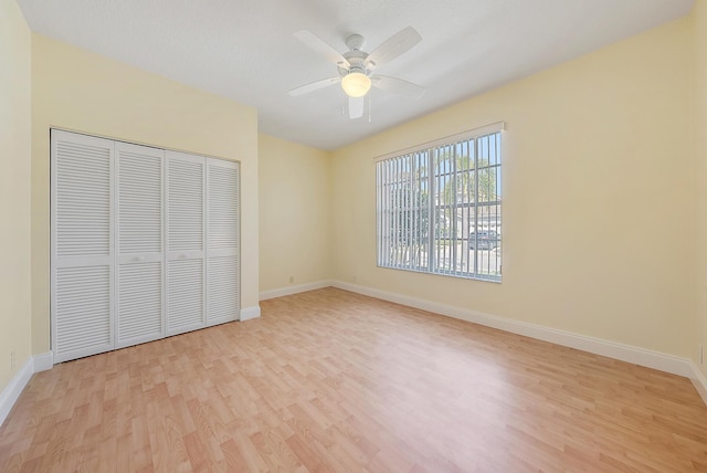 unfurnished bedroom with a closet, ceiling fan, and light wood-type flooring