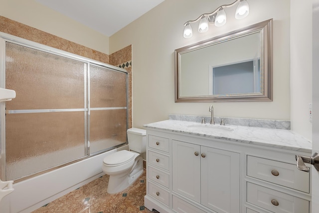 full bathroom with vanity, bath / shower combo with glass door, and toilet