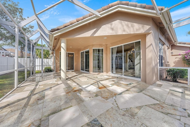 rear view of property with a lanai and a patio area