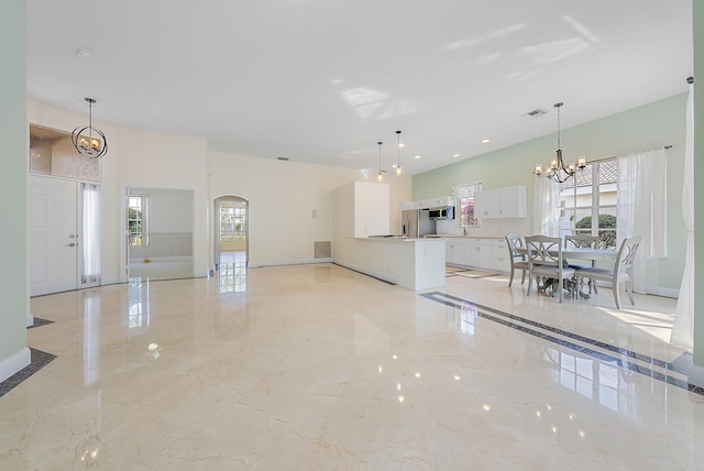 kitchen featuring hanging light fixtures, white cabinetry, an inviting chandelier, and stainless steel appliances