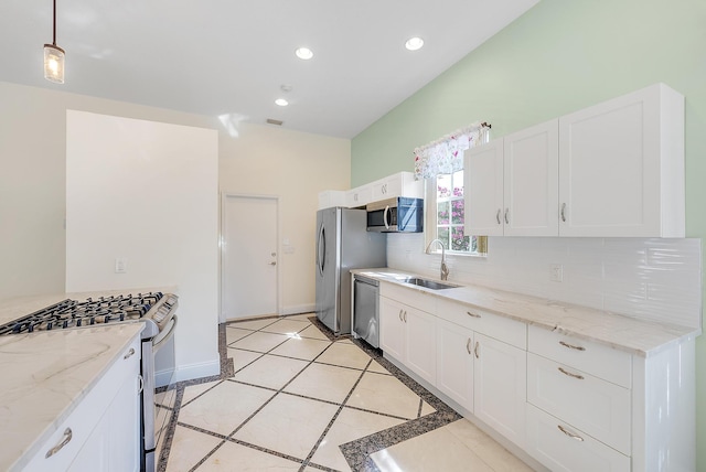 kitchen featuring tasteful backsplash, sink, white cabinets, and appliances with stainless steel finishes