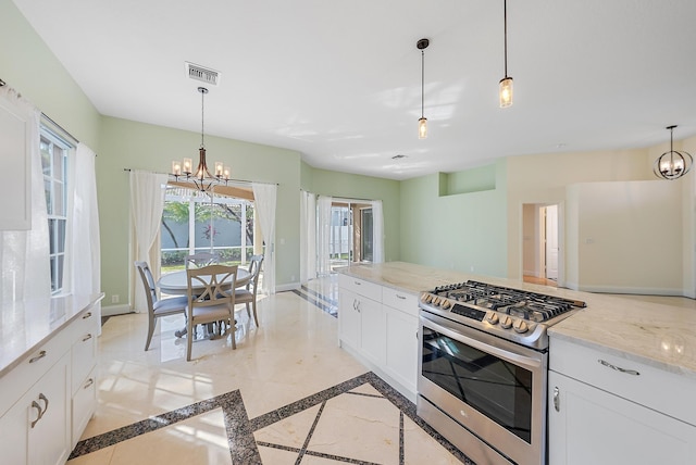 kitchen with gas range, white cabinetry, light stone counters, hanging light fixtures, and a notable chandelier