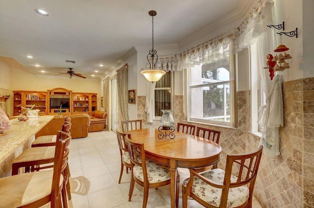 dining area featuring ceiling fan, light tile patterned floors, crown molding, and tile walls