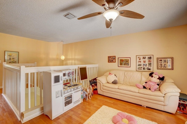 living room with a textured ceiling and light wood-type flooring