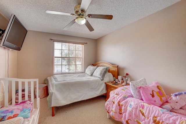 carpeted bedroom with ceiling fan and a textured ceiling