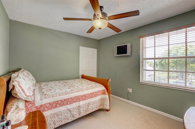 bedroom featuring ceiling fan, carpet, and a textured ceiling