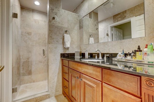 bathroom featuring backsplash, tile walls, an enclosed shower, and vanity