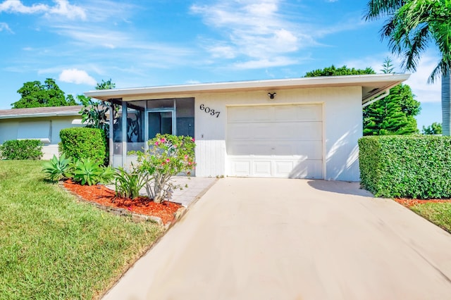 ranch-style home with a front yard, a garage, and a sunroom