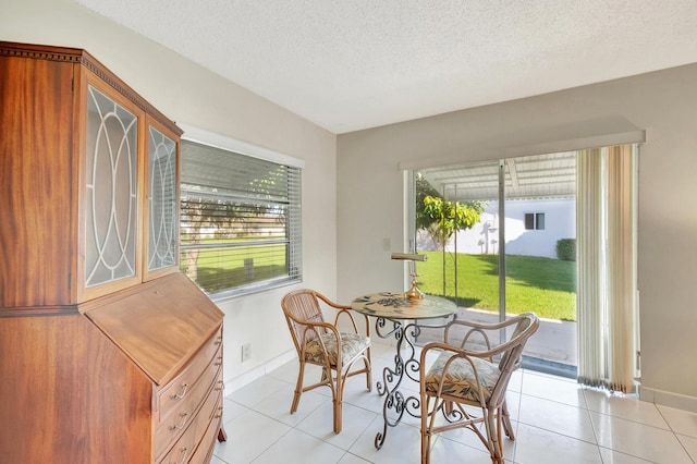 dining area with light tile patterned floors and a textured ceiling