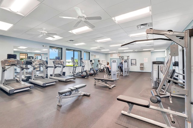 exercise room with ceiling fan and a paneled ceiling