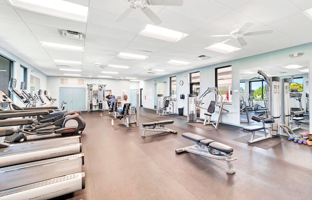 workout area with ceiling fan and a paneled ceiling