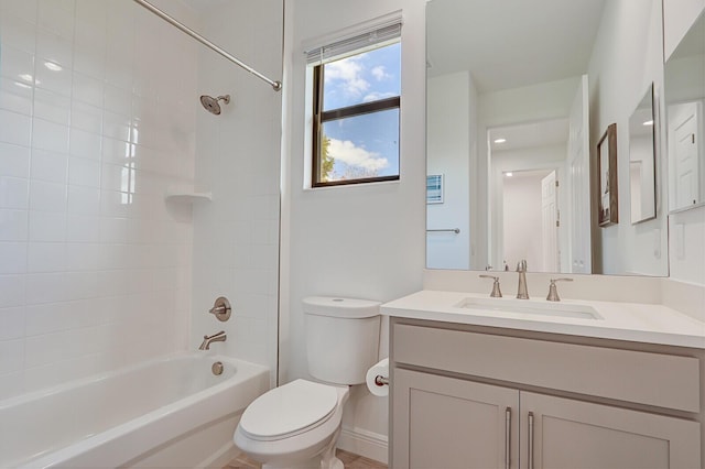 full bathroom featuring tiled shower / bath, vanity, and toilet