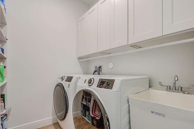 clothes washing area with independent washer and dryer, cabinets, light hardwood / wood-style floors, and sink