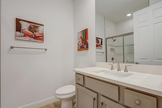 bathroom with an enclosed shower, vanity, and toilet