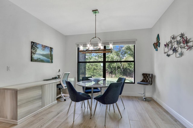 dining space with a notable chandelier and light hardwood / wood-style flooring