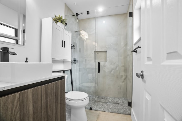 bathroom with tile patterned floors, walk in shower, vanity, and toilet