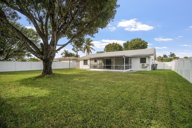 rear view of property featuring a sunroom and a yard