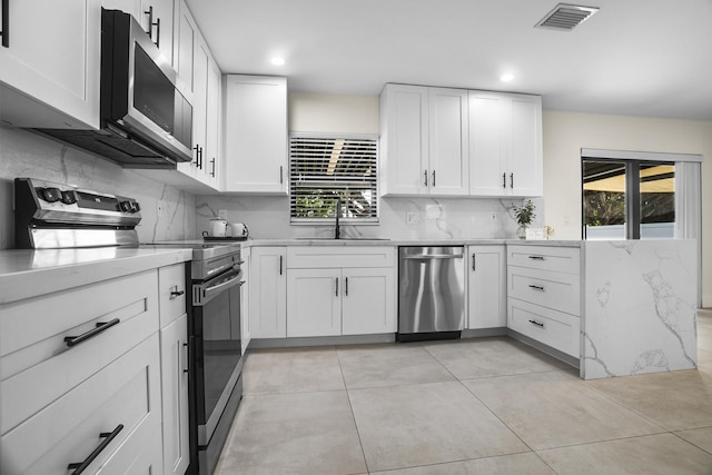 kitchen with sink, white cabinetry, appliances with stainless steel finishes, and plenty of natural light