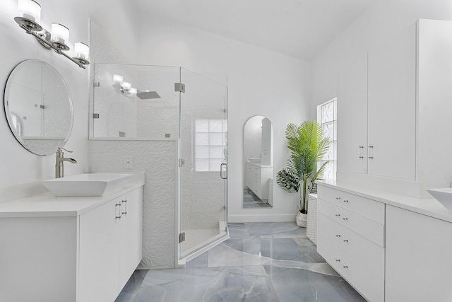 bathroom featuring a shower with shower door and vanity