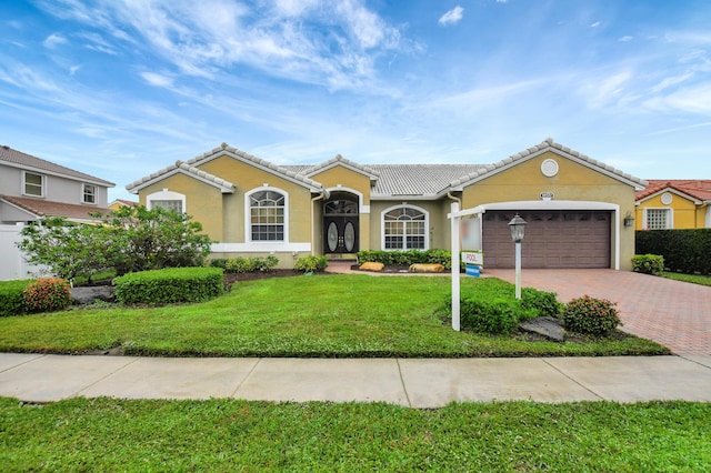 single story home with a garage and a front lawn