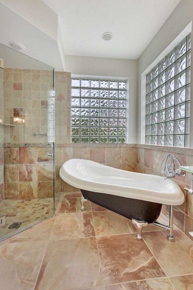 bathroom featuring independent shower and bath and tile walls