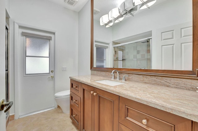 bathroom featuring a shower with door, toilet, tile patterned flooring, and vanity