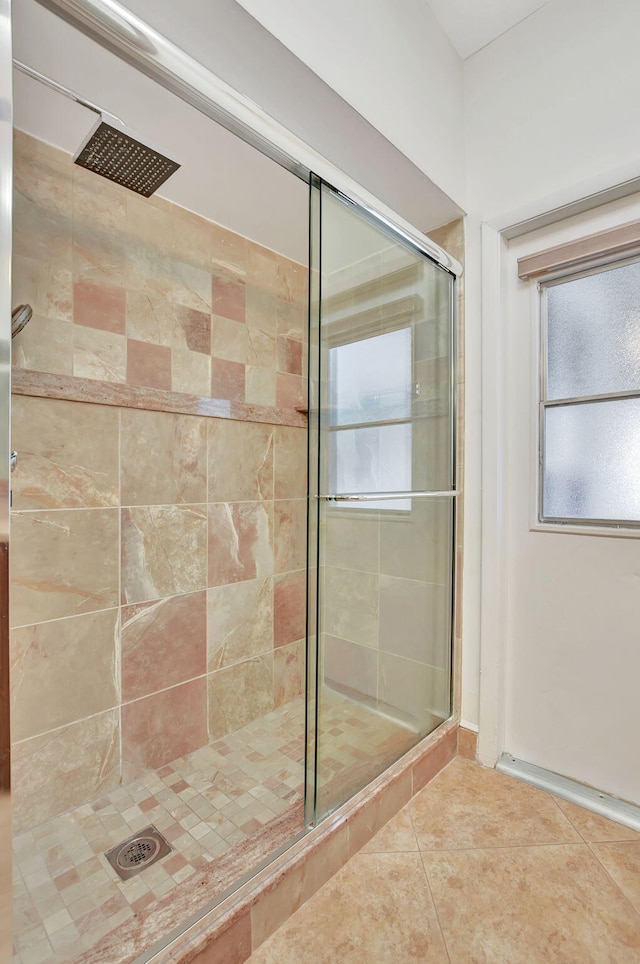 bathroom with a shower with shower door and tile patterned floors