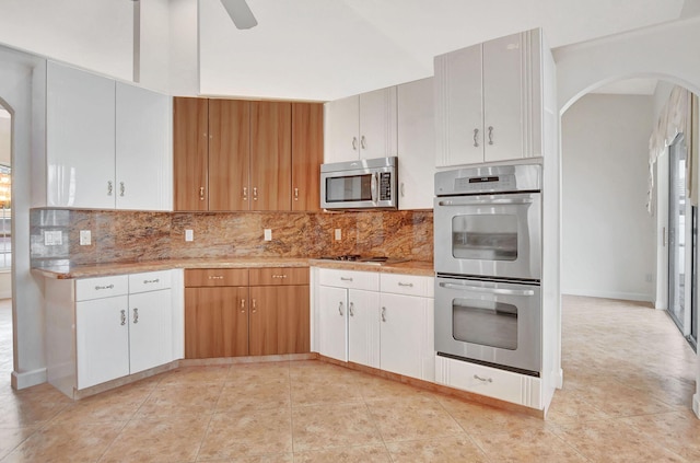 kitchen with white cabinets, stainless steel appliances, and decorative backsplash