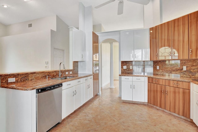 kitchen featuring light stone countertops, decorative backsplash, stainless steel dishwasher, white cabinets, and sink