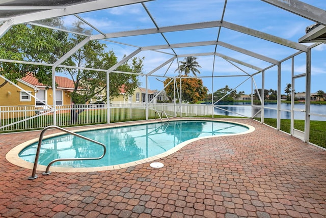 view of swimming pool with glass enclosure, a water view, and a patio