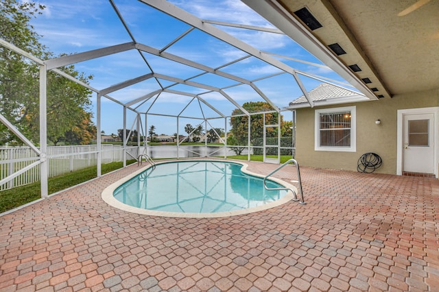 view of pool featuring a patio area, a lanai, and a water view