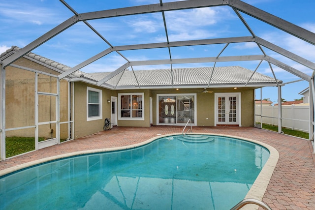 view of pool featuring glass enclosure, a patio area, ceiling fan, and french doors