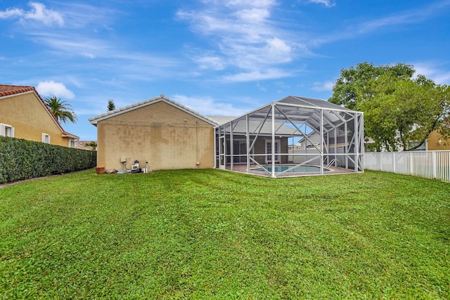 back of property featuring a fenced in pool, a lanai, and a yard