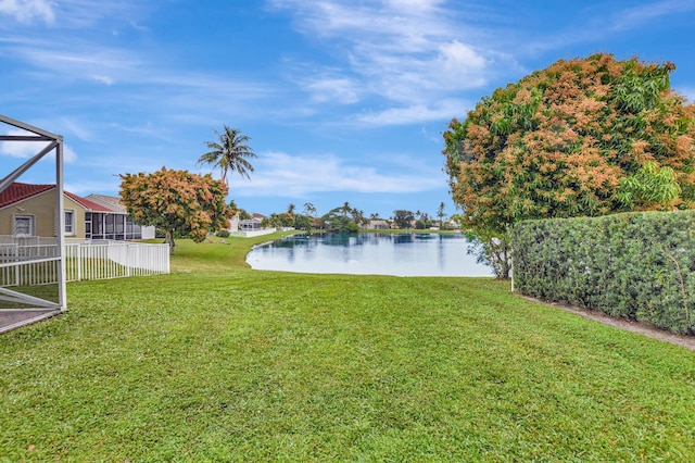 view of yard with glass enclosure and a water view