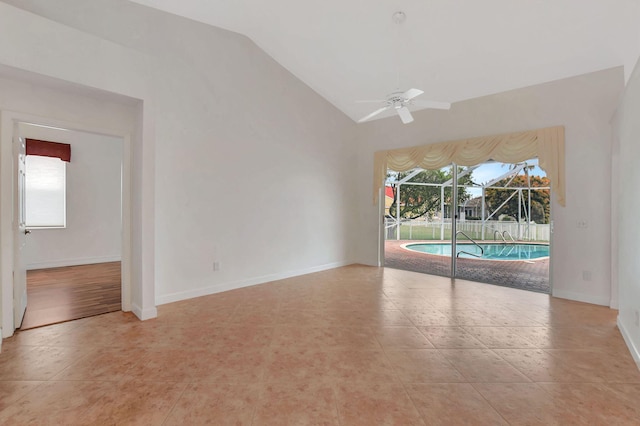 spare room with ceiling fan, light tile patterned floors, and vaulted ceiling