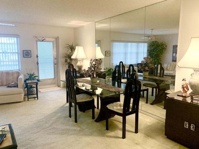 dining area featuring light colored carpet and a textured ceiling