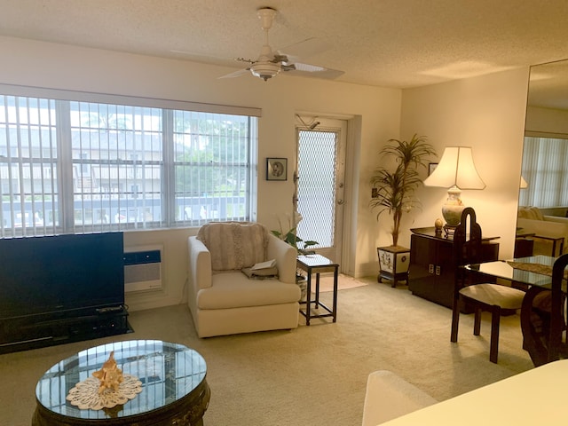 living room with a textured ceiling, ceiling fan, and carpet