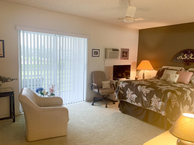 bedroom with an AC wall unit, a textured ceiling, carpet floors, access to exterior, and ceiling fan