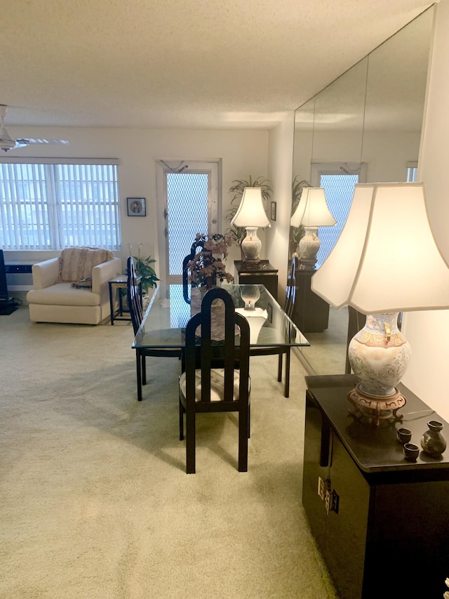 carpeted dining space with ceiling fan