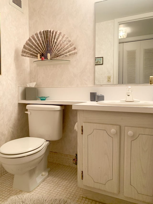 bathroom with toilet, tile patterned flooring, and vanity