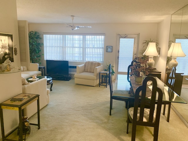 carpeted living room featuring ceiling fan and a textured ceiling