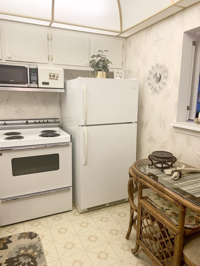 kitchen with white cabinetry and white appliances