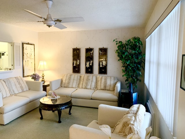 carpeted living room featuring ceiling fan and a textured ceiling