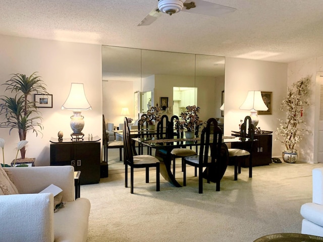 carpeted dining space featuring a textured ceiling and ceiling fan