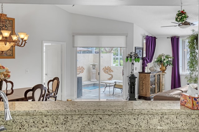 kitchen with lofted ceiling and ceiling fan with notable chandelier